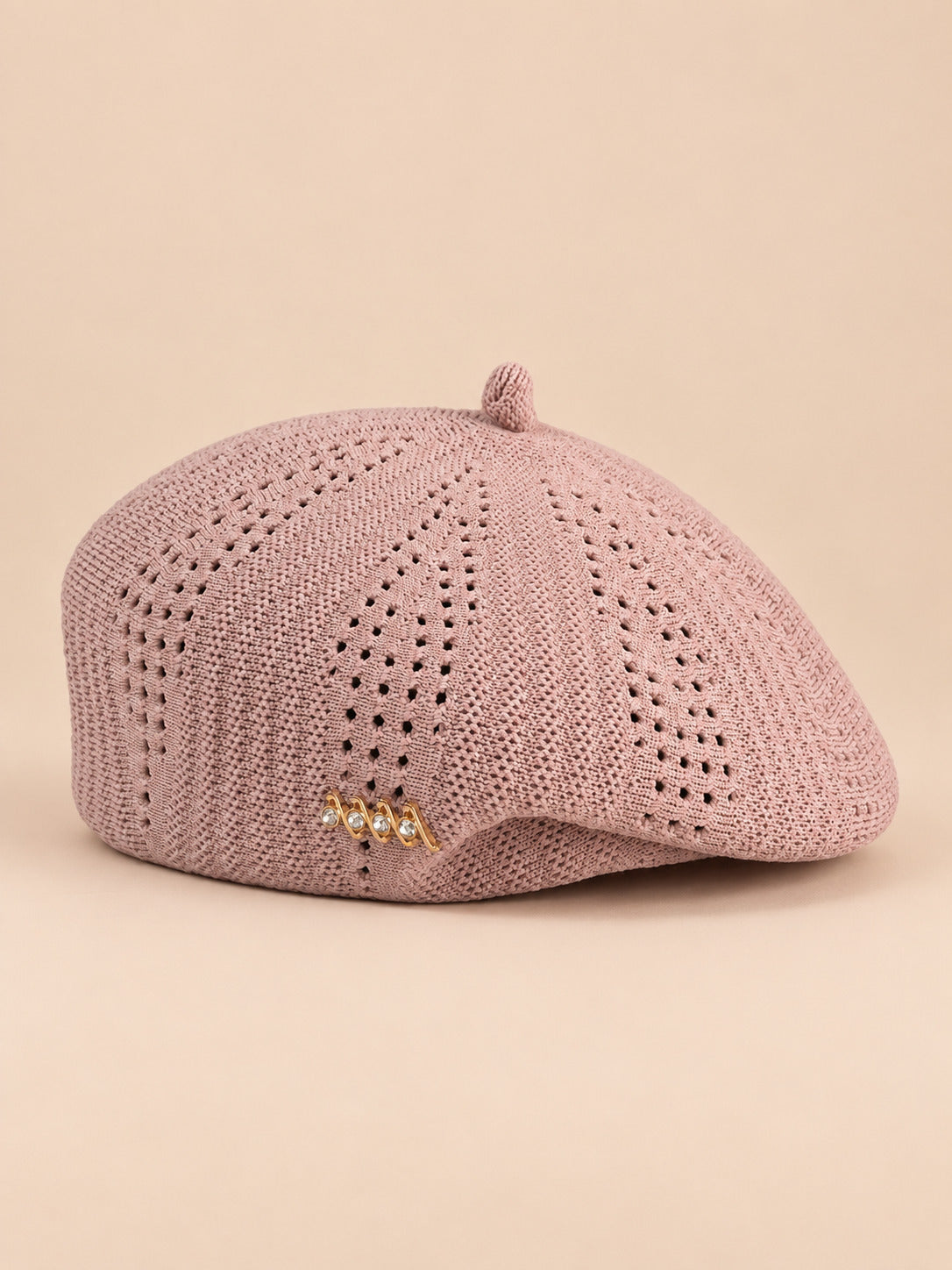 Béret ajouré style japonais rose, vue de face sur fond pêche sable
