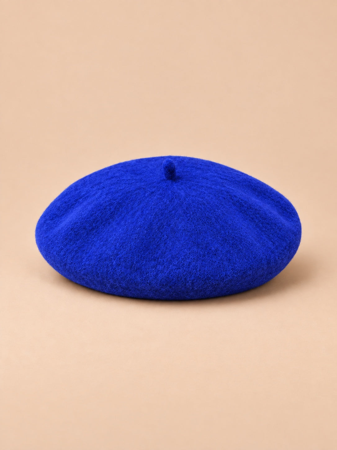 Béret d’artiste femme en laine mélangée vintage, coloris 010, vue de face sur fond sable pêche.