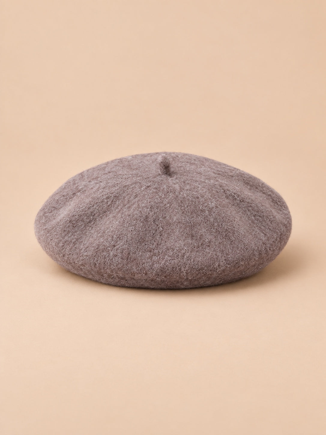 Béret d’artiste femme en laine mélangée vintage, coloris 012, vue de face sur fond sable pêche.