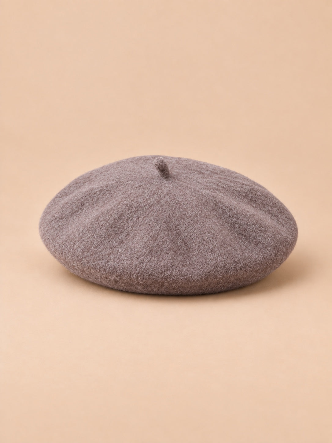 Béret d’artiste femme en laine mélangée vintage, coloris 012, vue de trois quarts sur fond sable pêche.