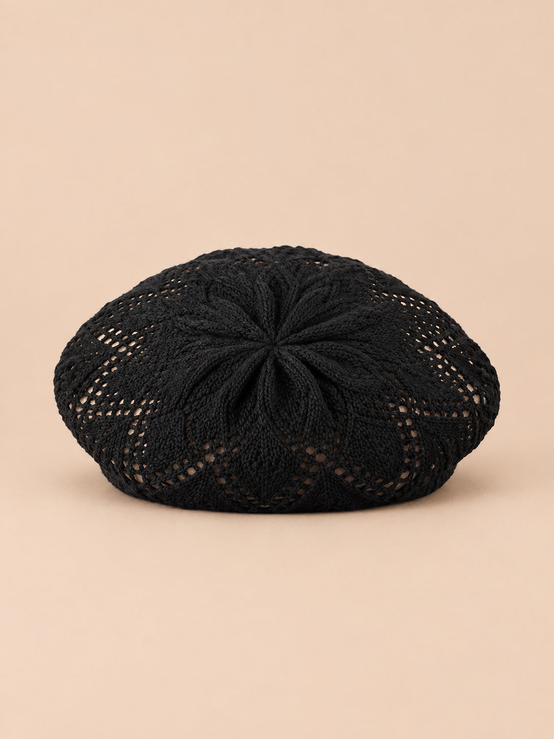 Béret d'artiste en maille fine Noir, vue de face sur fond pêche sable