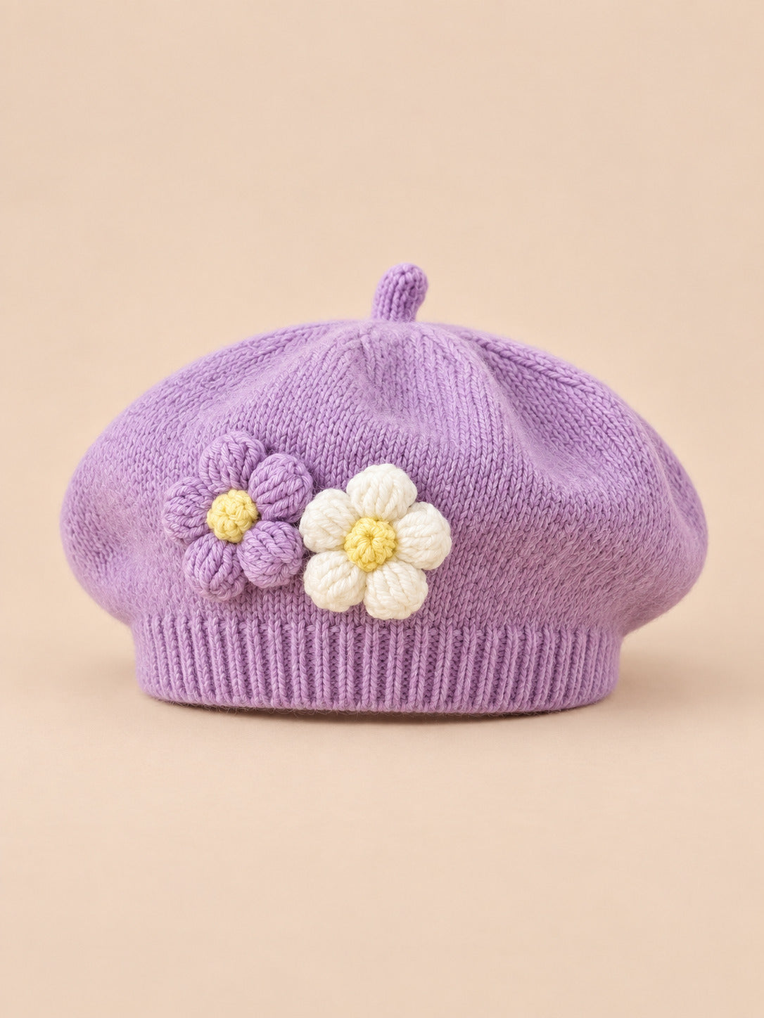 Béret bébé fille Violet à fleurs en relief au crochet, vue de face sur fond pêche sable