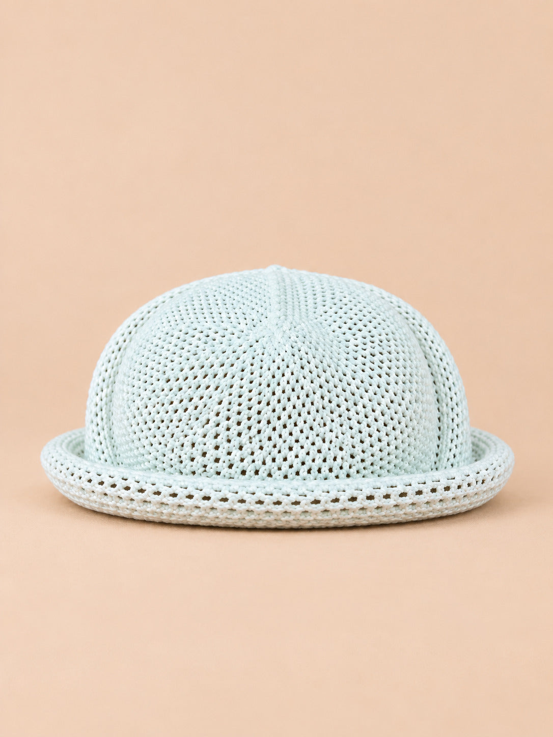 Béret bibi ajouré blanc, vue de face sur fond pêche sable