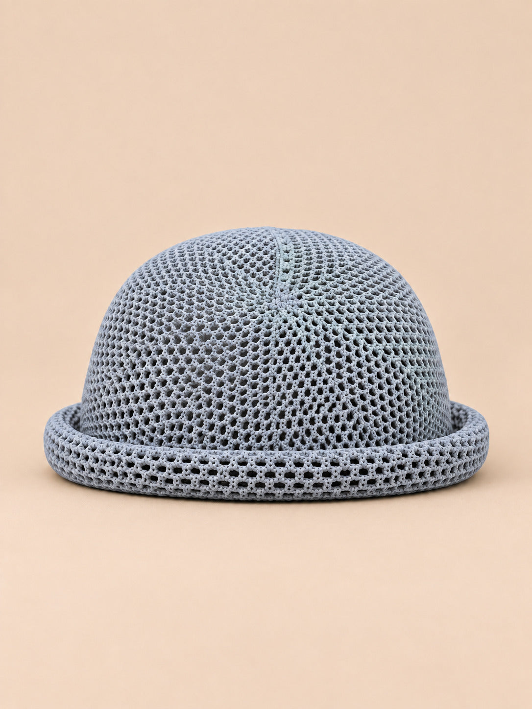 Béret bibi ajouré gris, vue de face sur fond pêche sable