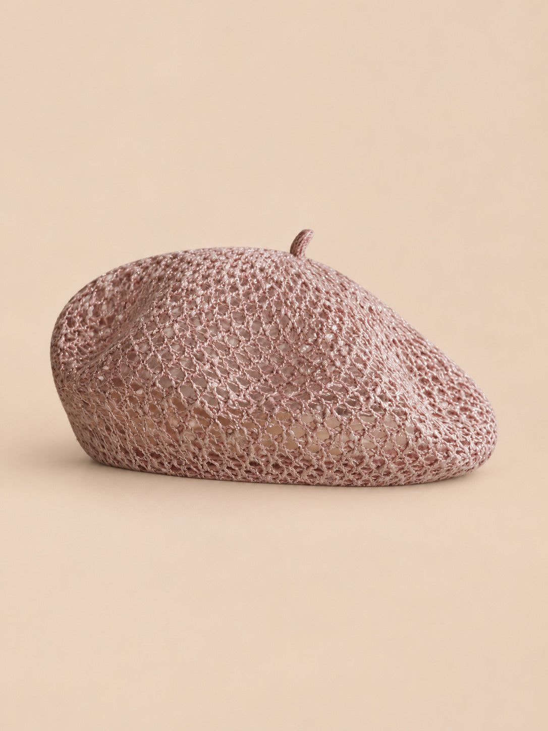 Béret citrouille ajouré rose, vue de face sur fond pêche sable