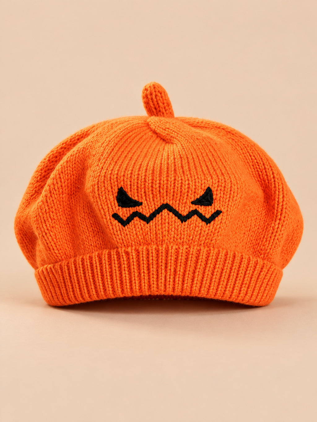Orangefarbenes Kinderbarett aus Strick mit gesticktem Kürbisgesicht als Halloween-Motiv, Vorderansicht