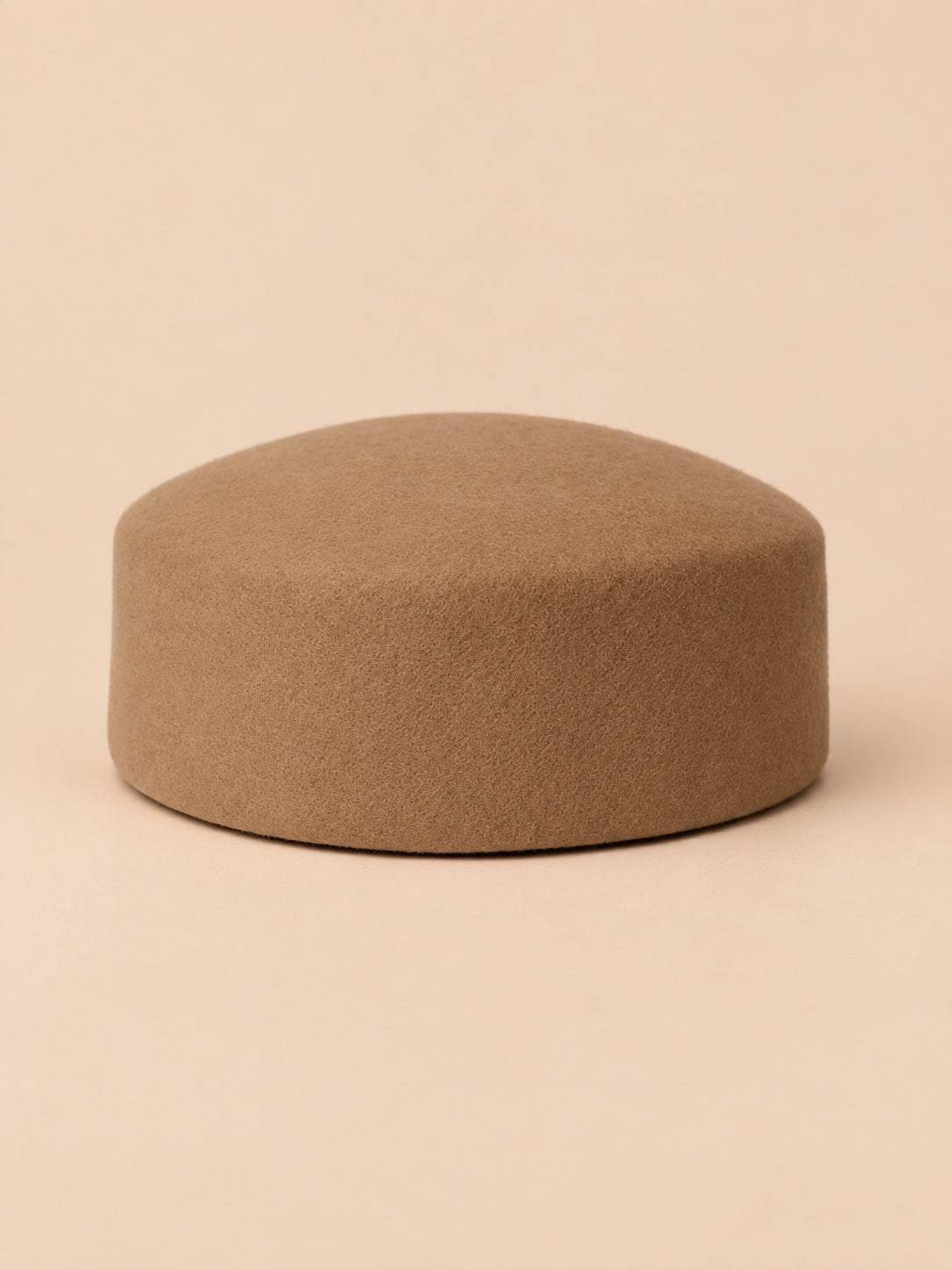 Béret femme en laine feutrée camel, forme plat, vue de face sur fond pêche sable
