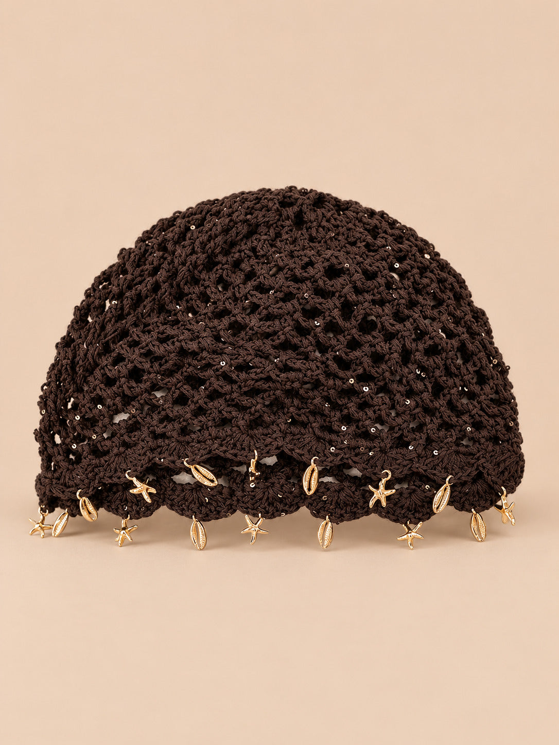 Béret rétro café ajouré au crochet à franges d'étoiles dorées, vue de face sur fond pêche sable