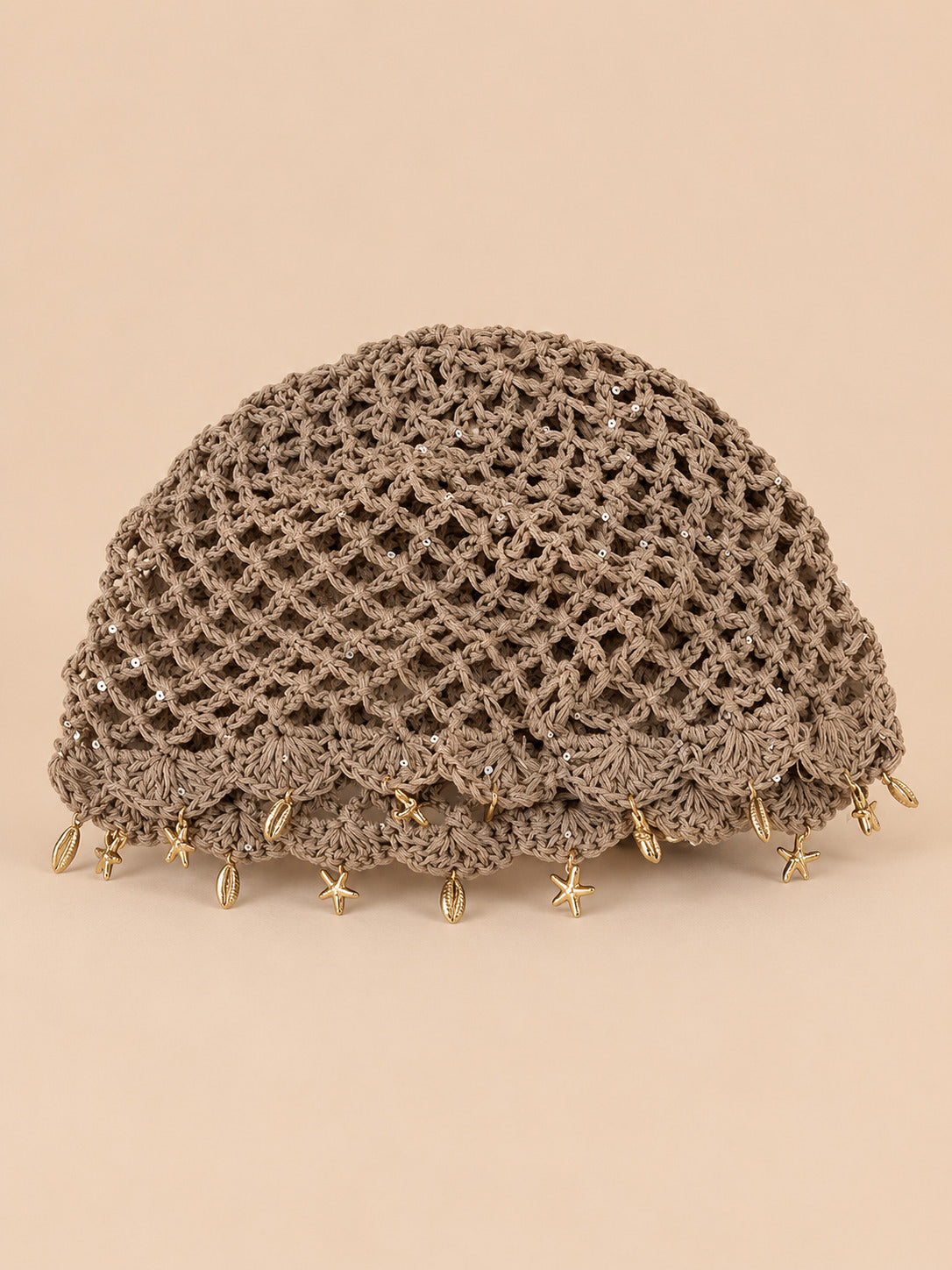 Béret rétro kaki ajouré au crochet à franges d'étoiles dorées, vue de face sur fond pêche sable