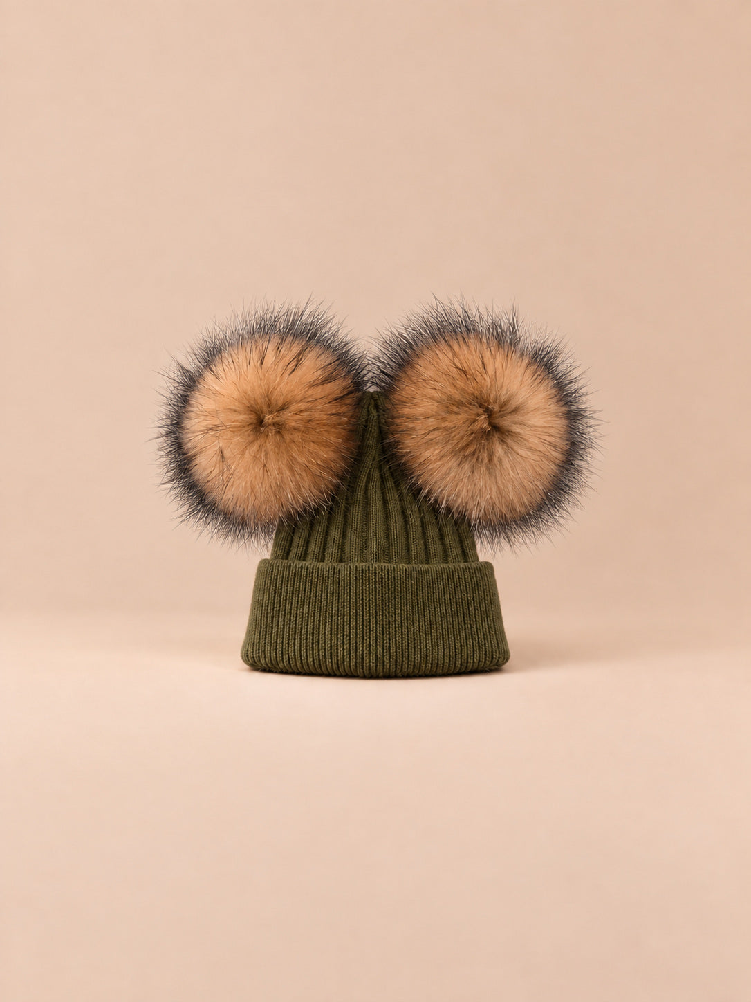 Bonnet double pompon, vert militaire, pompons naturels, vue de face sur fond pêche sable.
