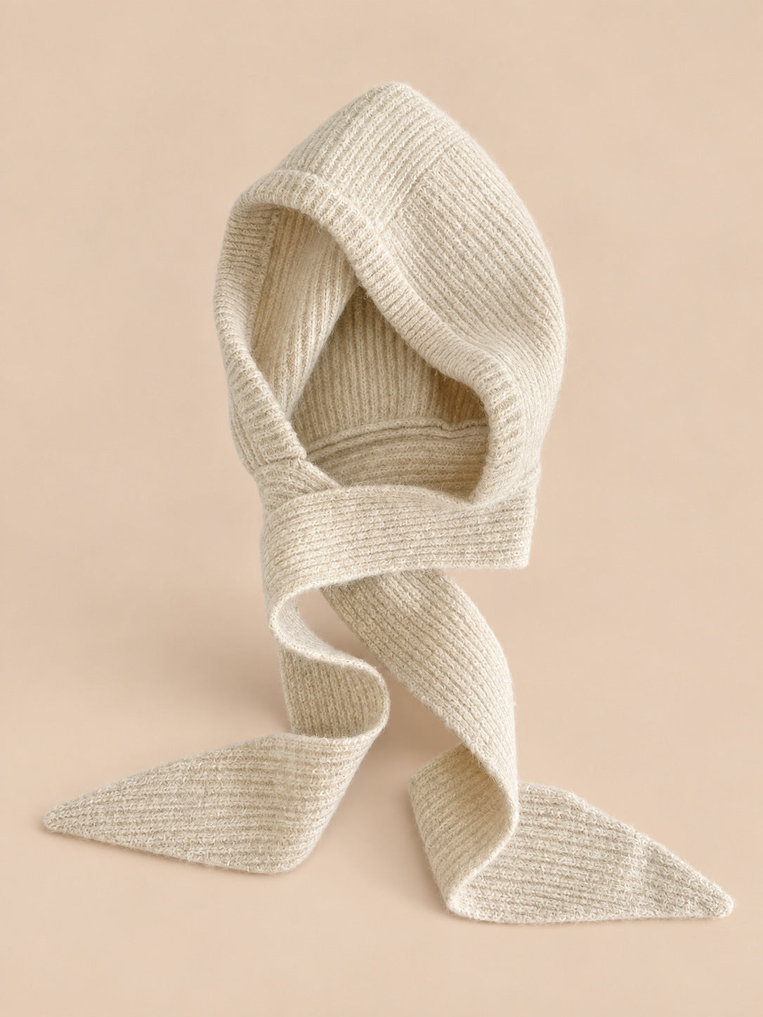 Cagoule bonnet-écharpe beige c en maille, vue de face sur fond pêche sable