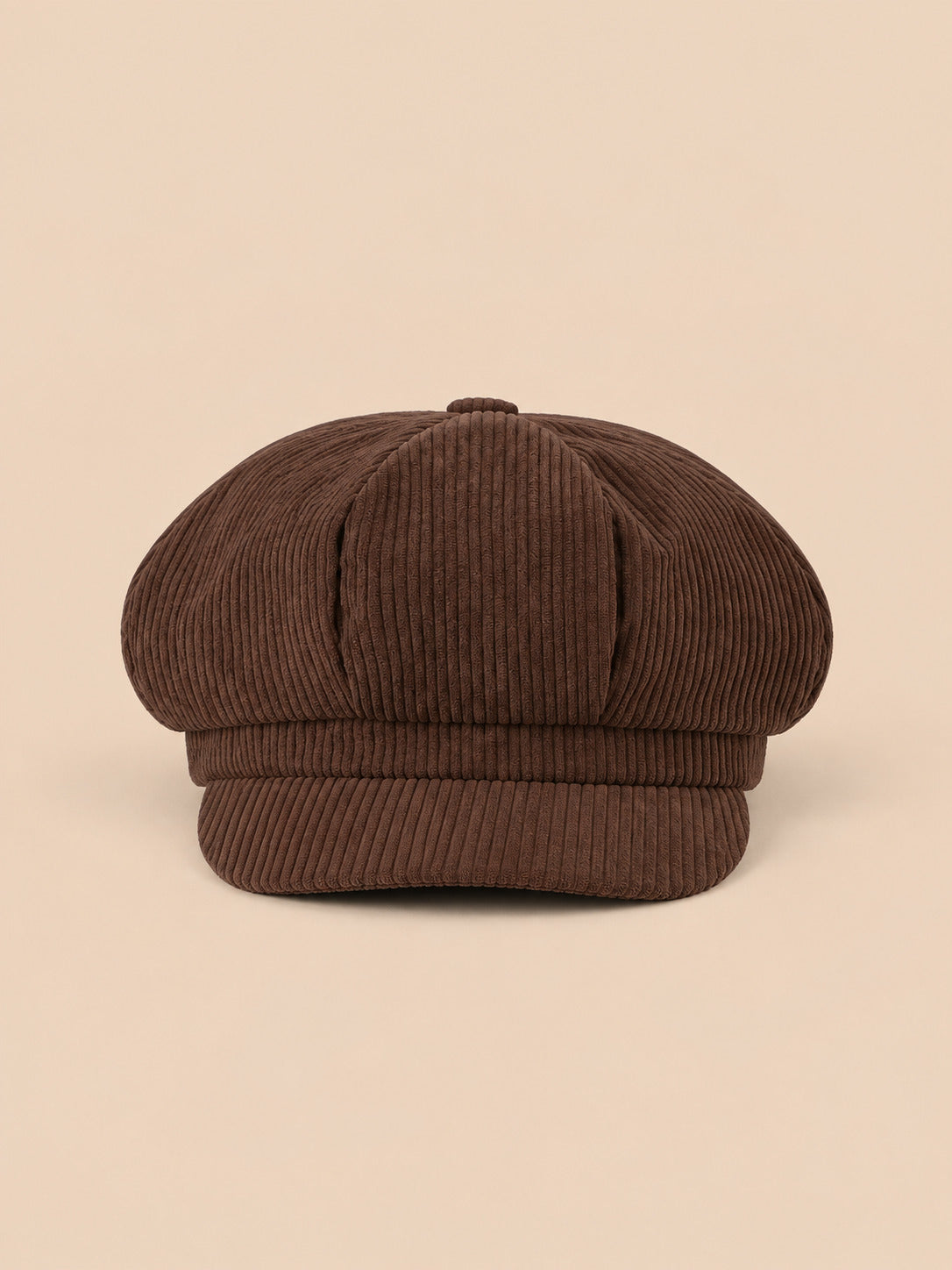 Casquette gavroche octogonale en velours côtelé marron, vue de face sur fond pêche sable