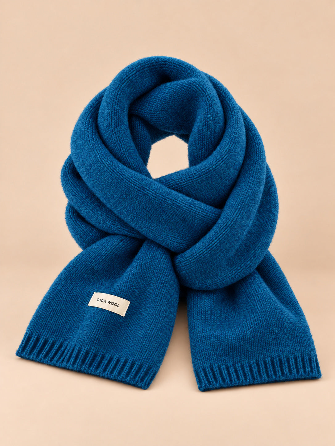 Écharpe unie classique, bleu paon, vue de face sur fond pêche sable.