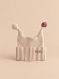 Kindermütze mit zwei Spitzen und kleinen Bommeln – Farbvariante Beige, Ansicht von vorn