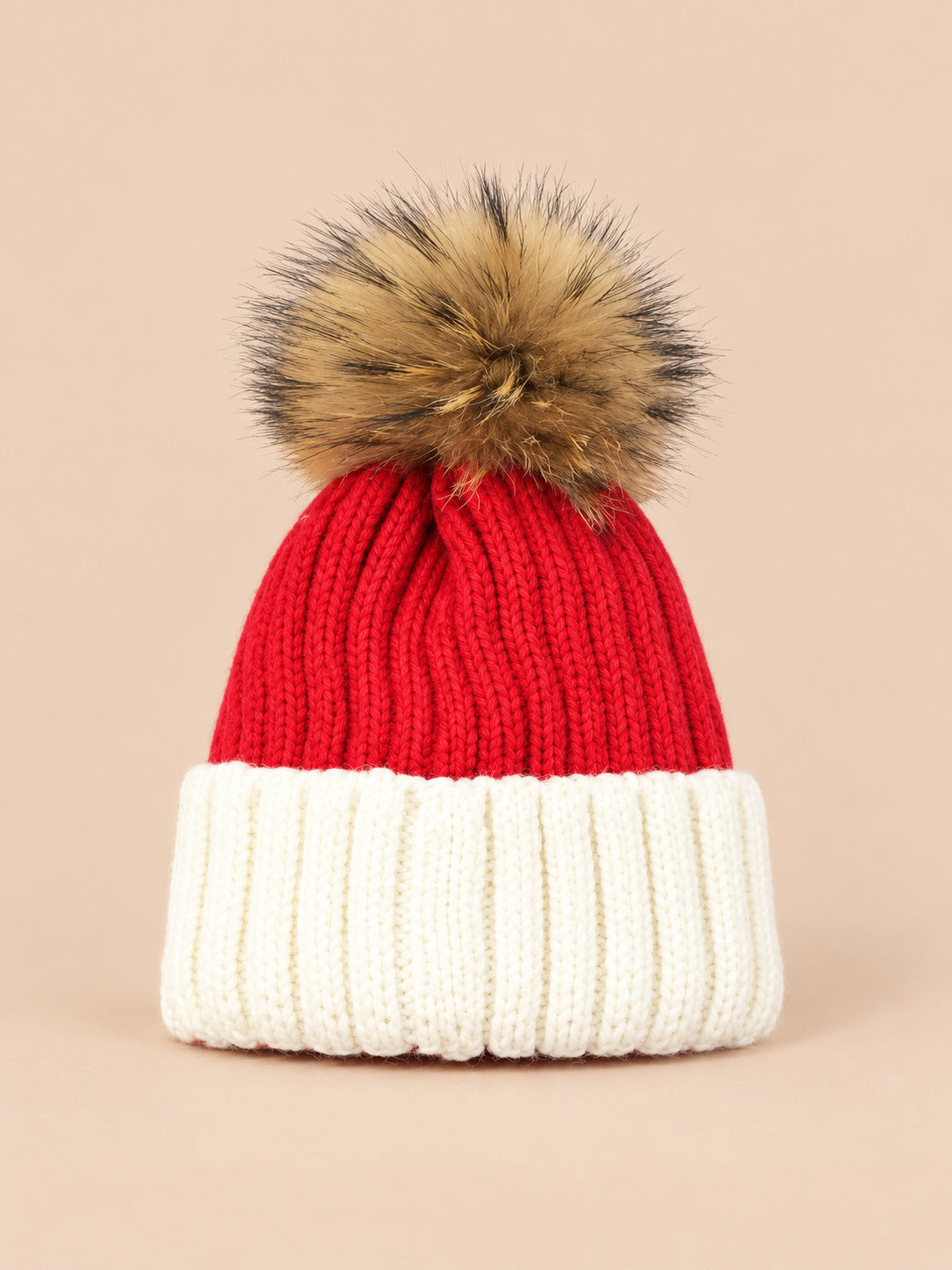 Bonnet enfant à pompon rouge 3, vue de face sur fond pêche sable