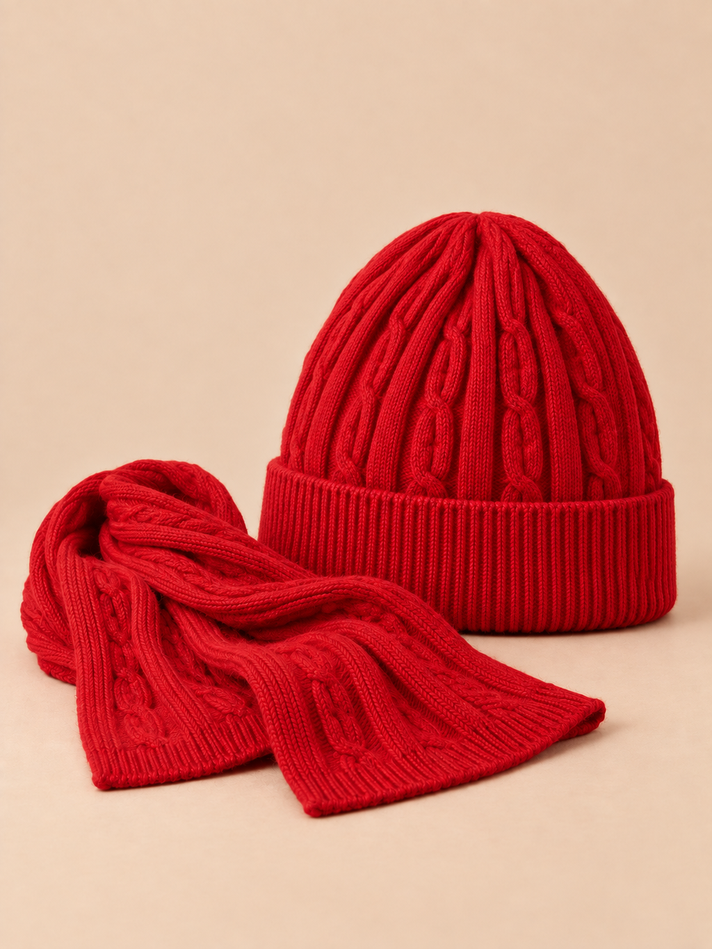 Mütze-Schal-Set aus dicker Jacquardwolle – Farbvariante Rot, Dreiviertelansicht, sand-pfirsichfarbener Hintergrund