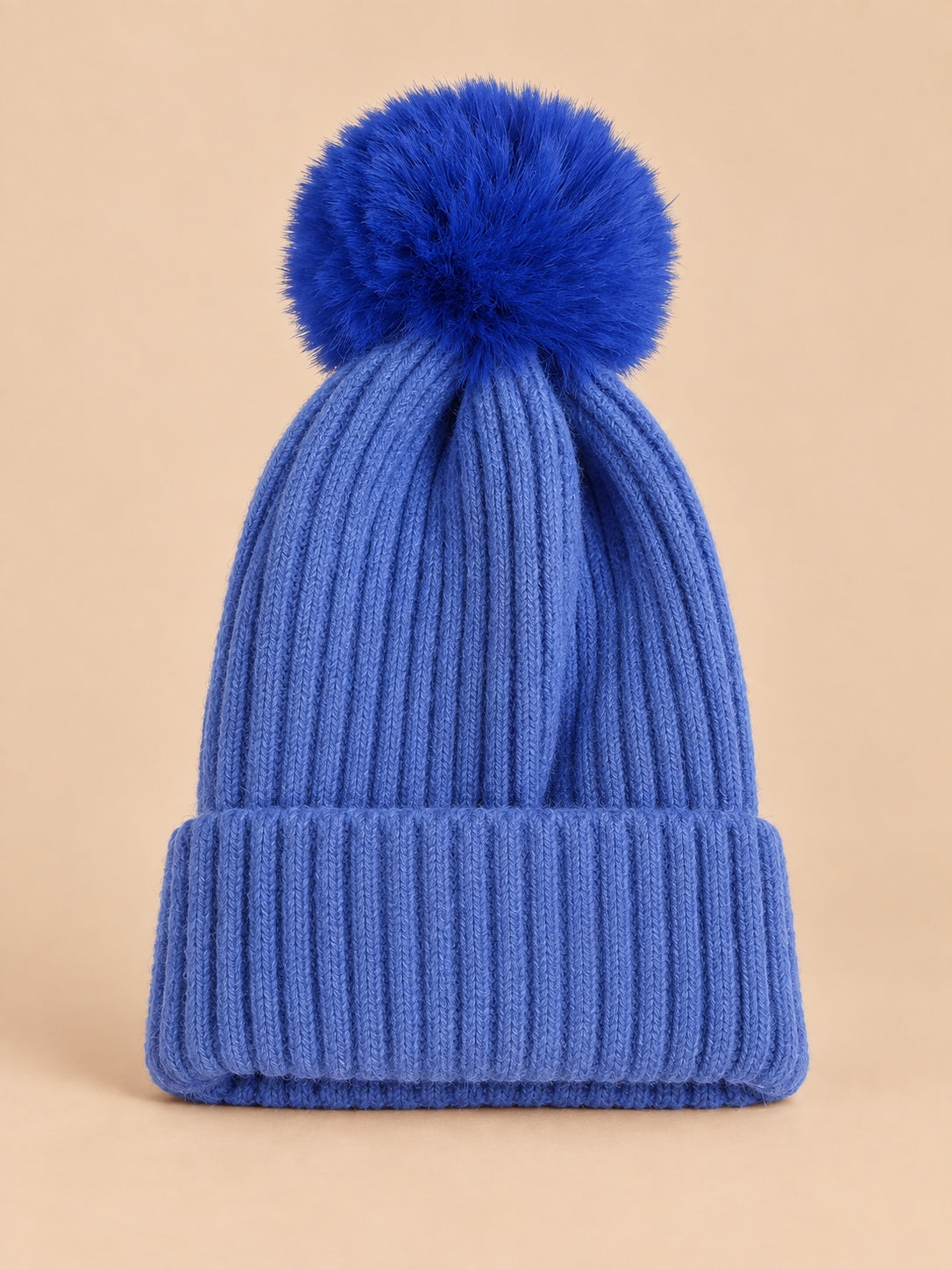 Bonnet de ski bleu sans logo à gros pompon bleu et revers côtelé, vue de face.