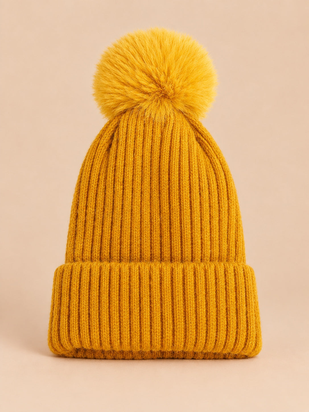 Bonnet de ski jaune sans logo à gros pompon assorti et revers côtelé, vue de face.