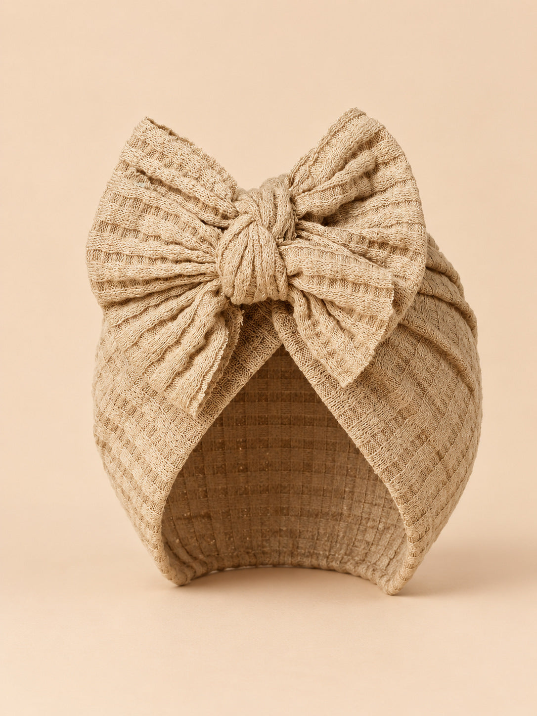Baby-Turbanmütze für Mädchen aus Baumwollstrick mit Knoten – Farbvariante Beige / Sand, Ansicht von vorn
